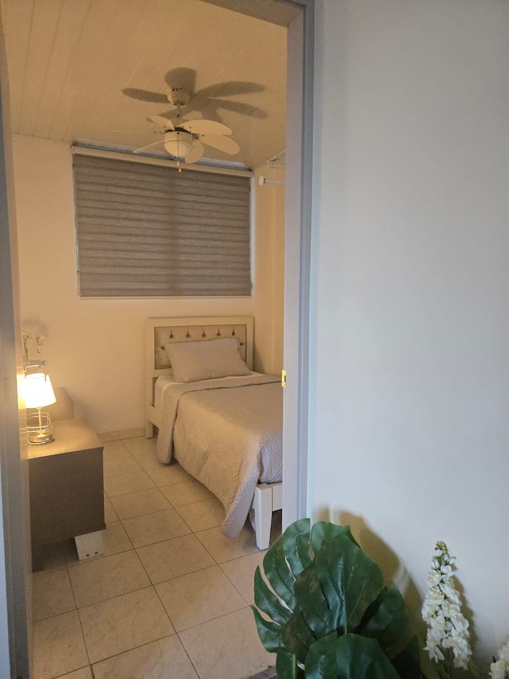 Топлината на тази стая ще ви накара да се почувствате като у дома си. Прохладна спалня с вентилатор на тавана и големи прозорци за естествен въздух или климатик в апартамента. 