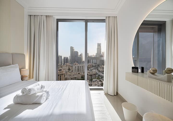 Chumba cha kulala chenye mwangaza chenye mandhari ya kupendeza ya Burj Khalifa, kinachotoa mapumziko yenye utulivu katikati ya Jiji la Dubai.