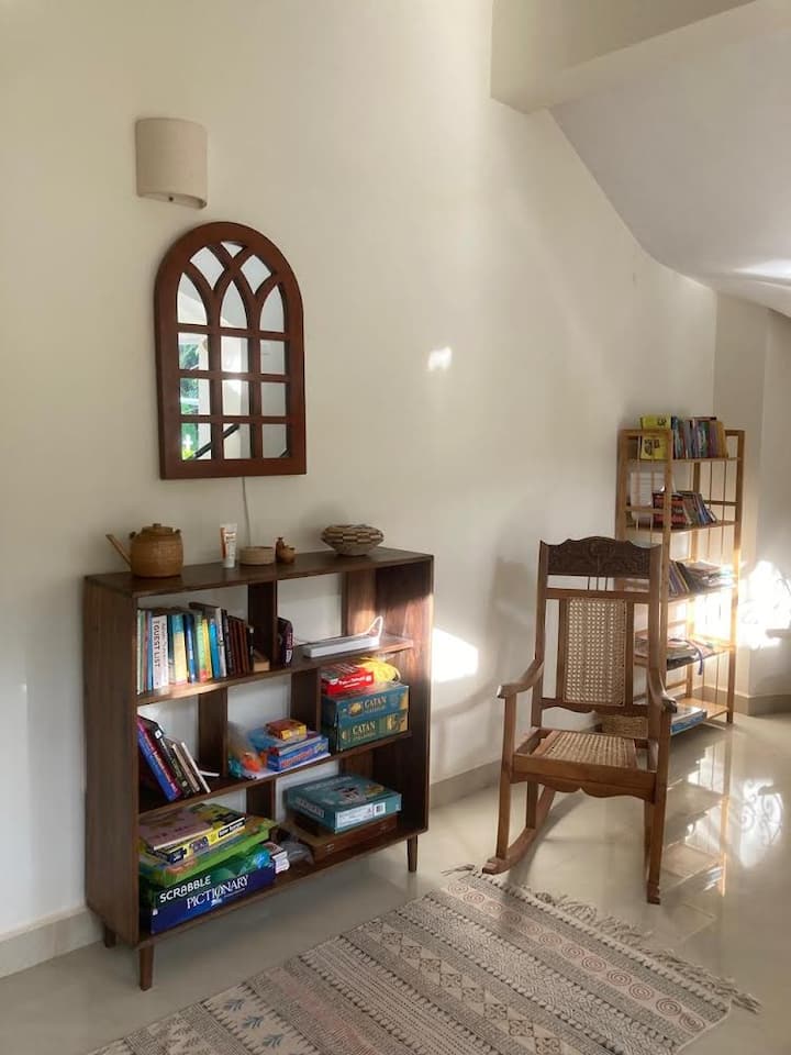 Books and games. Children’s bookshelf is behind the rocking chair.