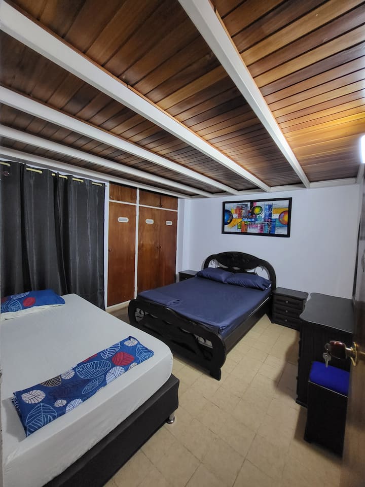 It has a double bed and a single box spring next to the dressing table and nightstands, creating a cozy and functional atmosphere.