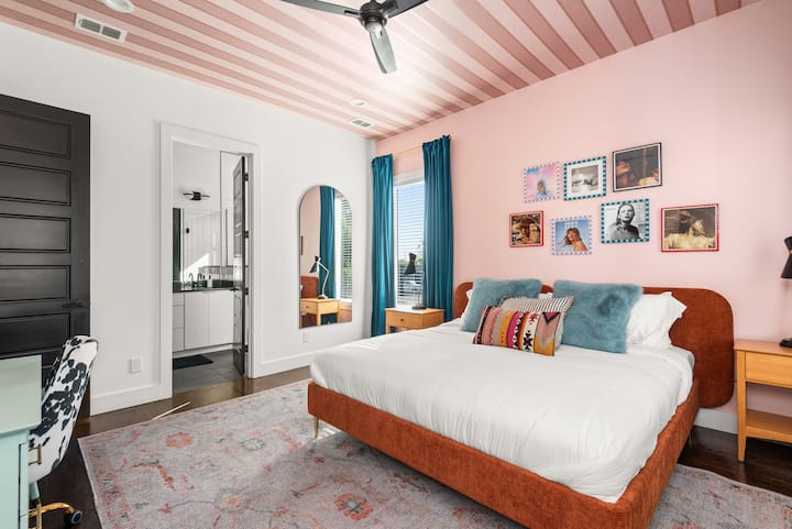 Დატკბით ამ სიცოცხლით სავსე მთავარ საძინებელში, სადაც გაჯერებული ტეილორ სვიფტის ხელოვნების ნიმუშები ნამდვილად უნიკალურ ატმოსფეროს ქმნის. Დიდი ზომის საწოლი ხრაშუნა თეთრი ზეწრებით იდეალური ადგილია დასვენებისა და დამუხტვისთვის