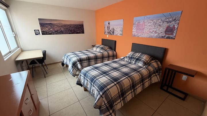 Recámara con 2 camas individuales y closet.