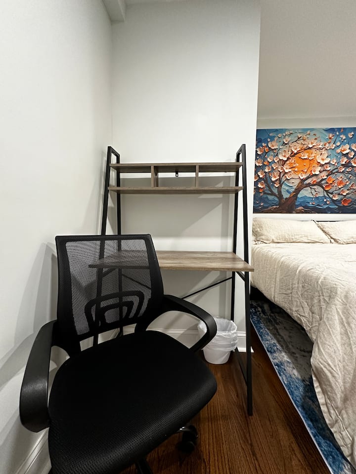 Espacio de trabajo funcional con silla, escritorio y zona para dormir cercana
