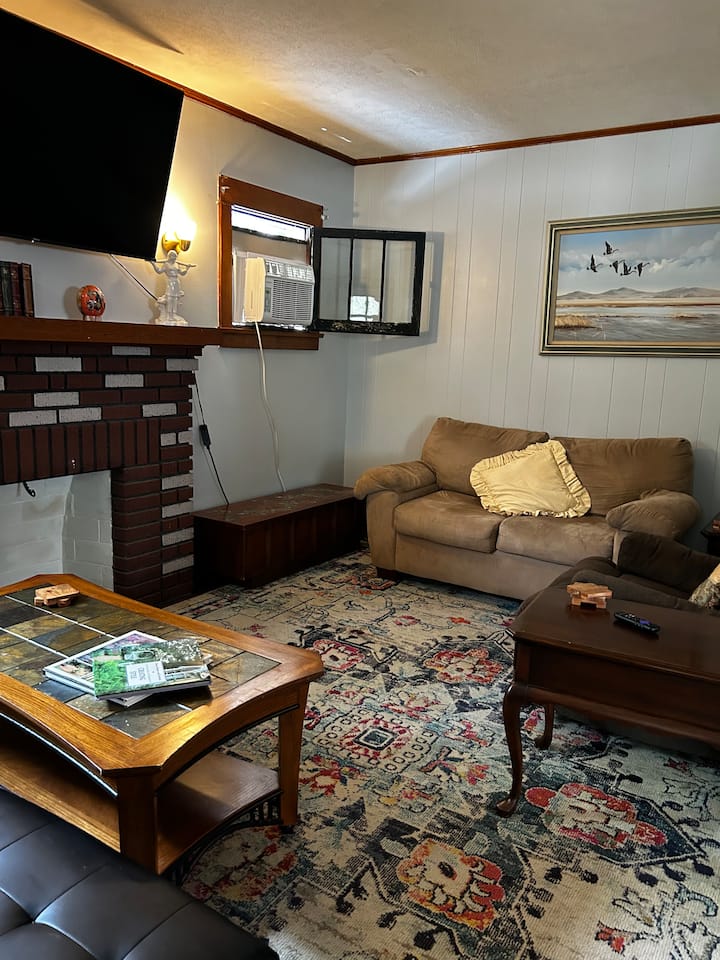 Living room with TV 
Comfortable chairs, coffee tables, and chest with bedding for sofa bed