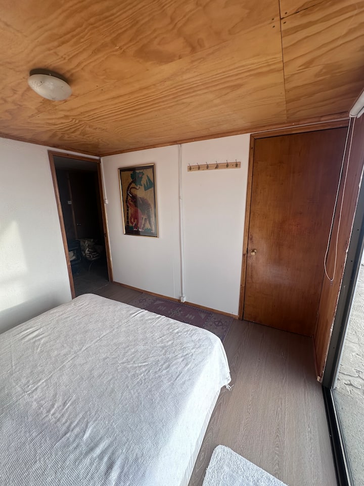 Hlavná spálňa s manželskou posteľou a malým šatníkom. 