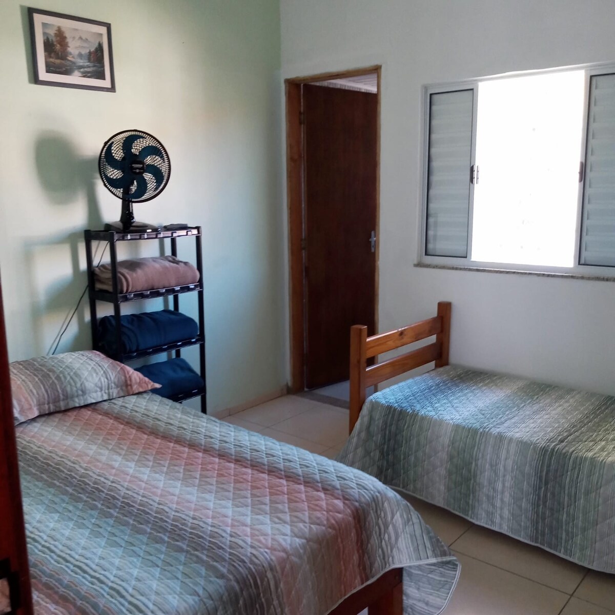 Საძინებლის კარგად განათებული ლუქსი კარგი ვენტილაციით, კარადა, ორადგილიანი საწოლი, ერთადგილიანი საწოლი, მაგიდის ვენტილატორი და ტელევიზორი (კუბი) ღია არხებით.