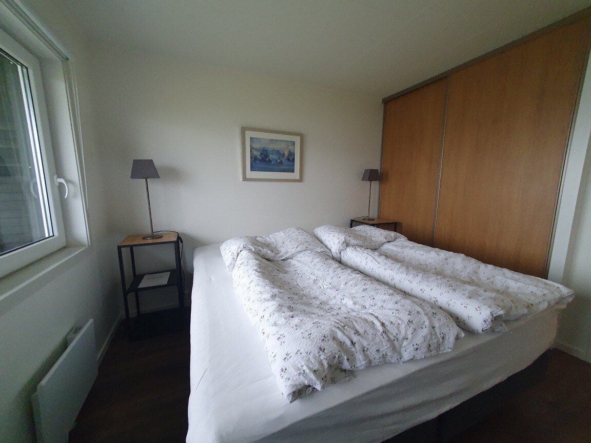 El dormitorio principal consta de una cama doble, mesita de noche y armario. Puerta al balcón privado con vistas al mar.