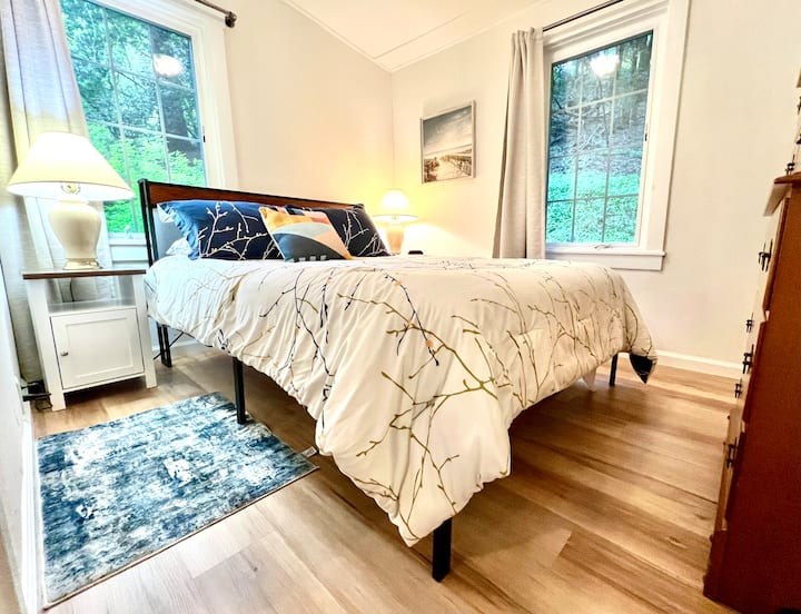 יש לנו מיטת קווין חדשה עם שקעי טעינה בראש המיטה. מנורה ושולחנות צד משני הצדדים.