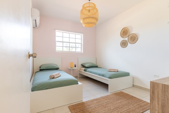 Táto útulná izba s dvoma samostatnými lôžkami je ideálna pre deti alebo priateľov, s jednoduchou výzdobou a dostatkom prirodzeného svetla.