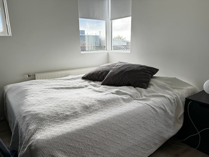 Spavaća soba u prizemlju s velikim krevetom, televizorom i radnim stolom. 