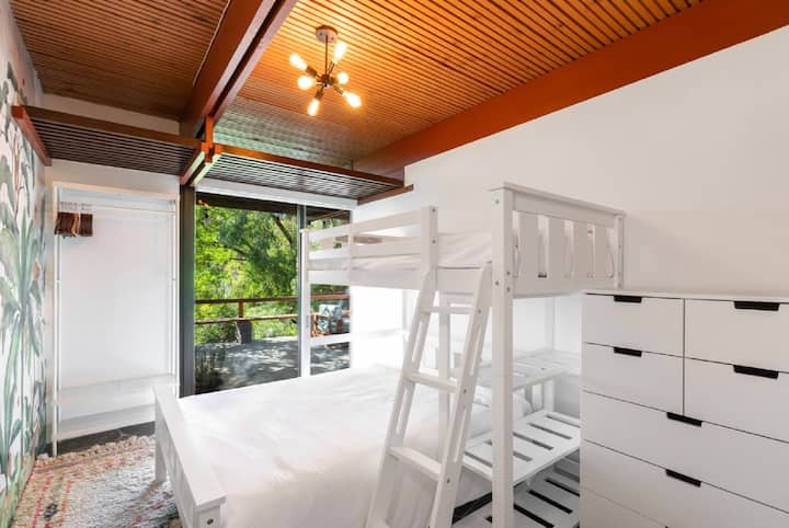 Poschodové postele s manželskou posteľou na spodnej strane a dvojitými posteľami na vrchnej strane. 