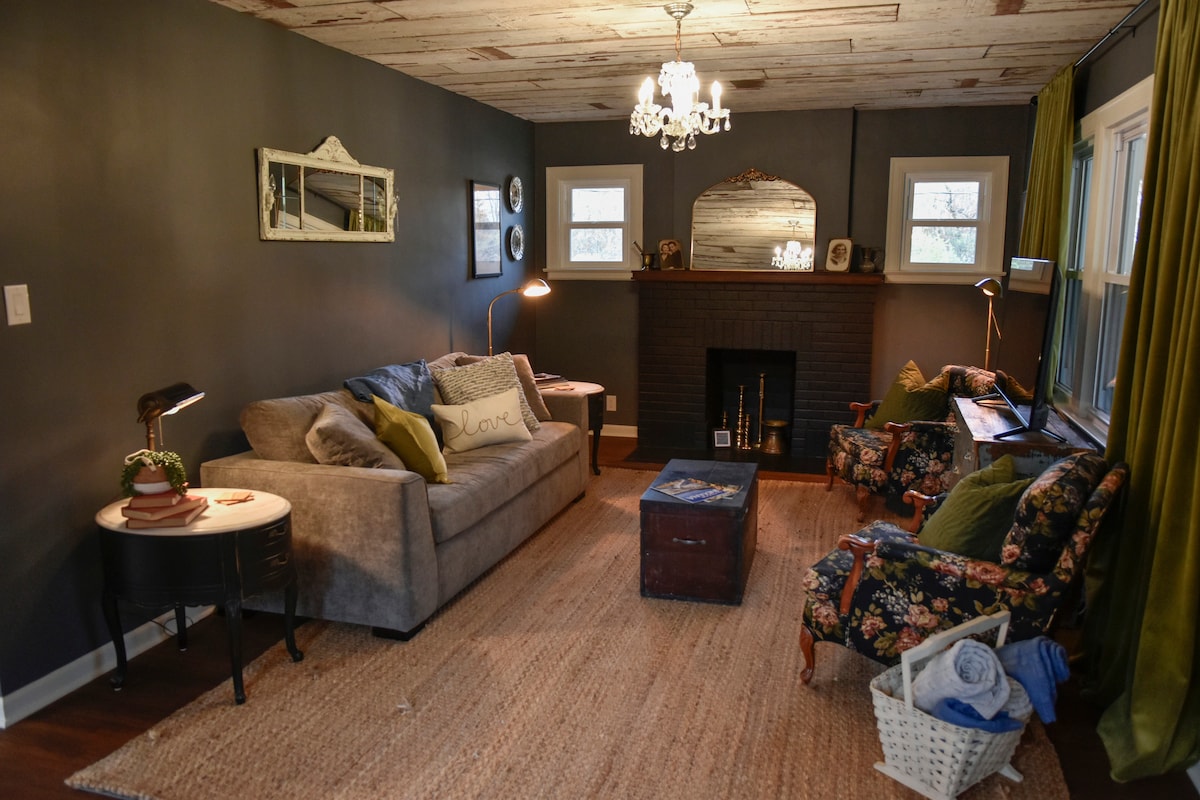 Gather around the brick fireplace and sink into the floral armchairs for slow mornings, movie nights, or quiet conversations. Every detail—from brass accents to antique artwork—adds to the farmhouse’s nostalgic warmth.