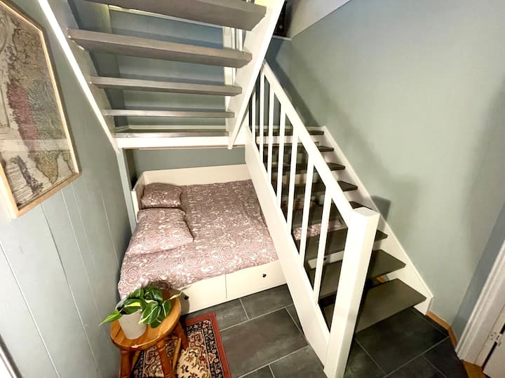 Кревет од 150 см под скалите. Ова не е посебна соба, но нуди приватност од другите простори.