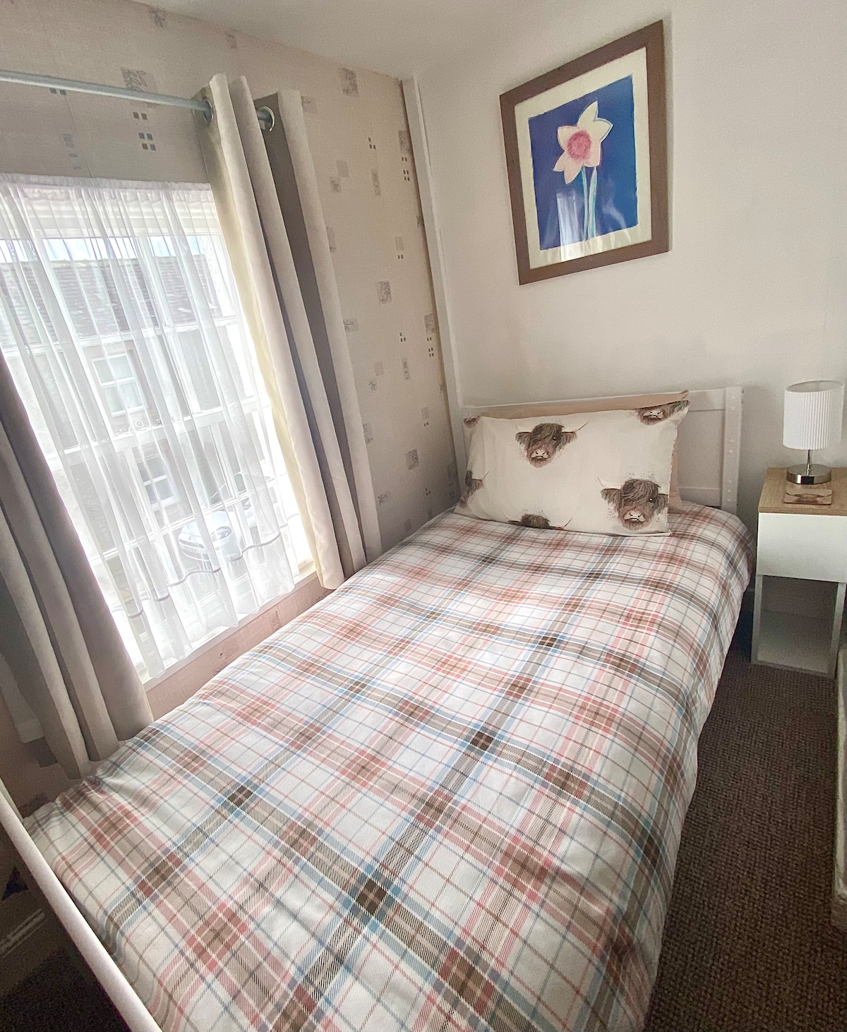 Galloway Cottage twin bedroom with bedside table & a large wardrobe with full length mirror.  The bedside lamp has a USB charging point.