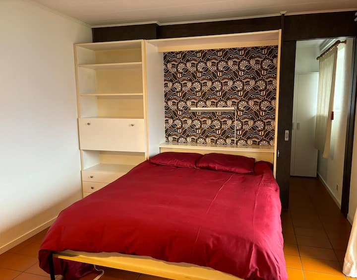 Krevat dopio (140 cm i gjerë) i cili është i palosur nga muri. Dera e hyrjes ndodhet këtu në të djathtë të fotografisë. Dy dhomat e gjumit janë të ndara nga dera rrëshqitëse.