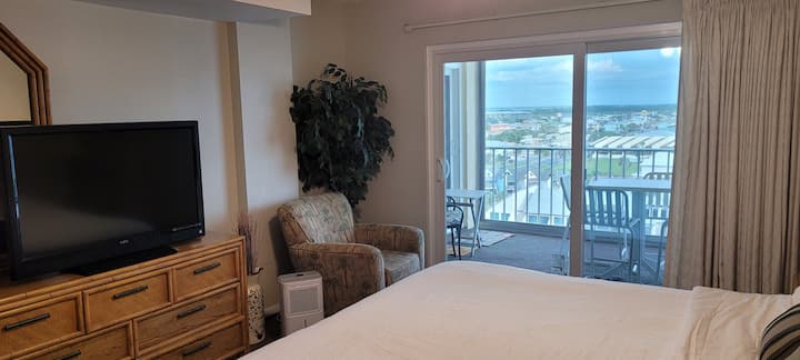 Amplio juego de habitación con cama tamaño king, 2 armarios, silla,televisión y vistas a la playa y a la orilla y más