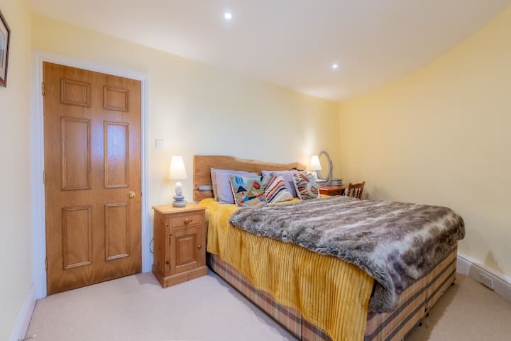 The super king bed in the en-suite bedroom is the best place to relax after a day of traveling