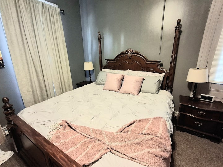 В тази предна спалня, която гледа към тихата улица, ще спите удобно на двойното легло. Завесите за затъмнение осигуряват тъмен, непрекъснат сън. Нощните шкафчета обгръщат леглото за удобно съхранение.