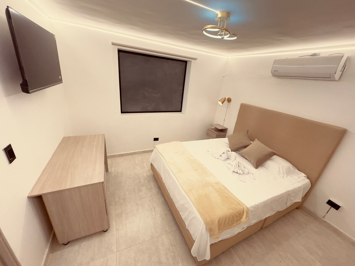 غرفة ممتعة مع مكيف هواء وتلفزيون ومكتب عمل، مثالية لعدم ترك عملك جانبًا.