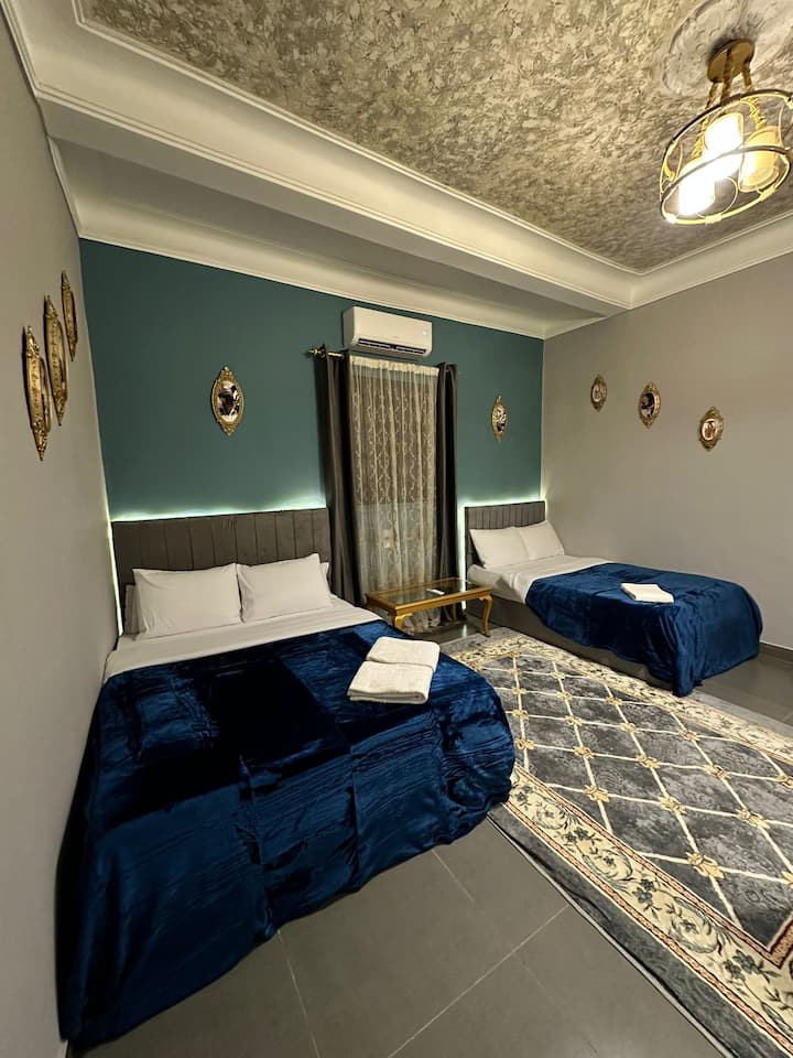 As you walk into the room, you’ll find two cozy double beds with fresh linen and soft towels, set in a serene blue ambiance for ultimate relaxation. 