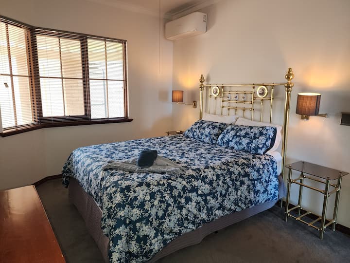 Queensize bed 
Lichte, luchtige slaapkamer met ochtendzon. 
Nachtkastjes en lampen. 