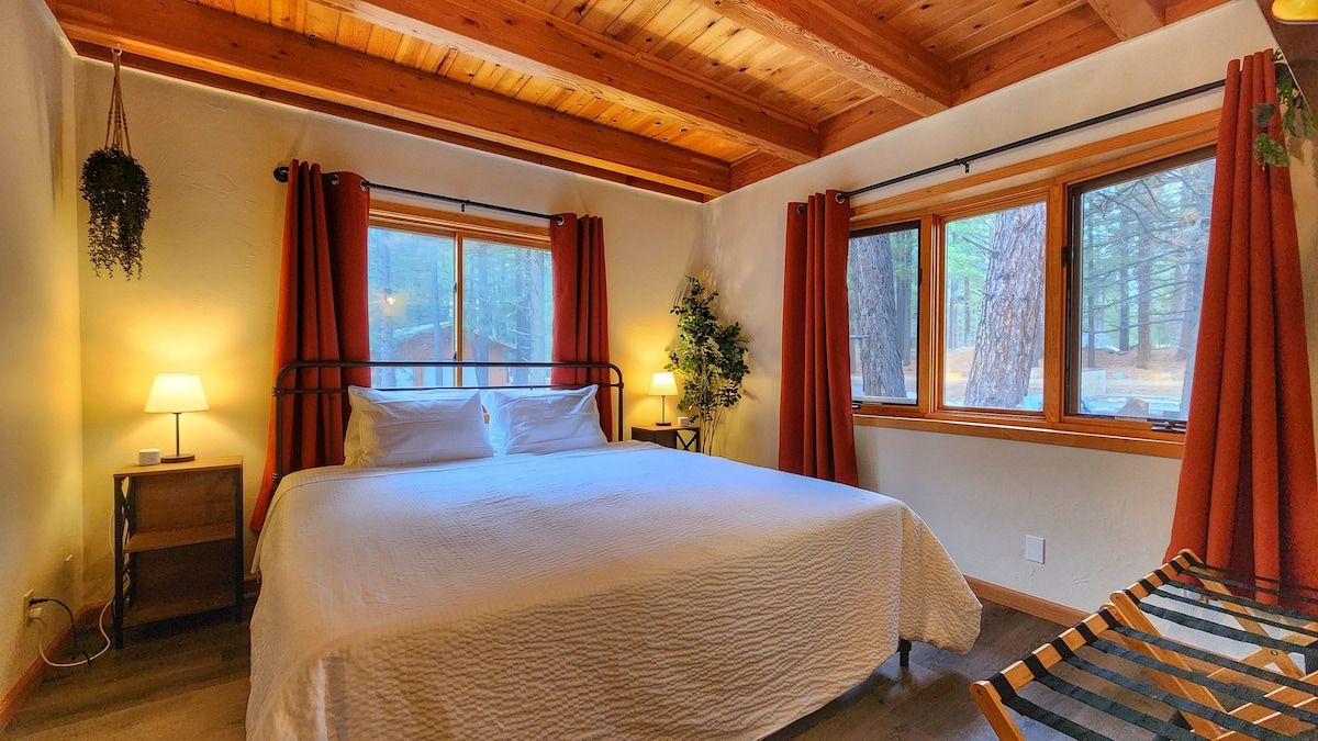 Dormitorio 1 (cama king en la planta baja)
- Cama King	
- Sábanas de categoría hospitalaria
- 4 almohadas: 2 firmes + 2 suaves
- Portaequipajes (x2), cubos de ropa de ruedas debajo de la cama, perchas
- Espejo de cuerpo entero
- Cortinas opacas.
- Estaciones de carga (USB-A y C, enchufes) 