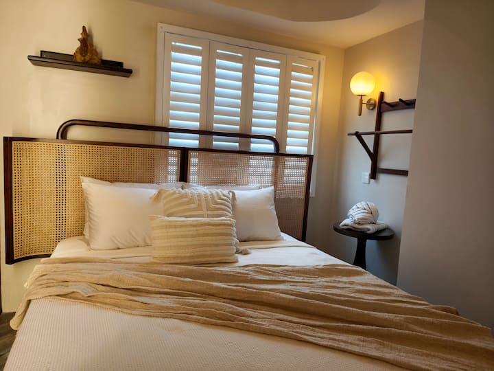 Primary queen bedroom with layered lighting.