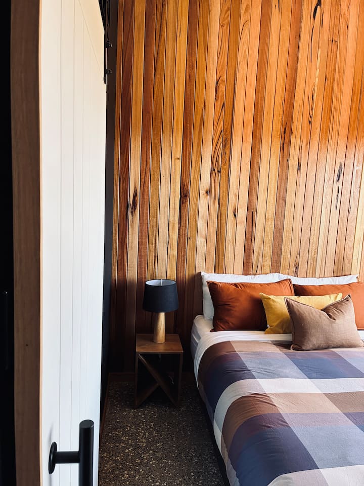 krevat dopio “Queen”, abazhurë krah krevatit dhe dollap i vogël i hapur me raft për valixhe 