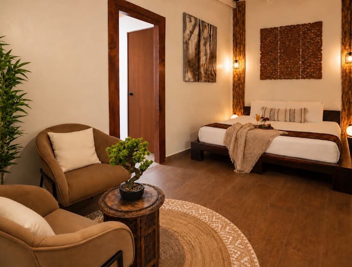 Esta habitación con aire acondicionado cuenta con una cama tamaño king y un par de tumbonas para relajarse. Una puerta conduce al baño, al armario y a un área adicional para dormir para dos personas adicionales.