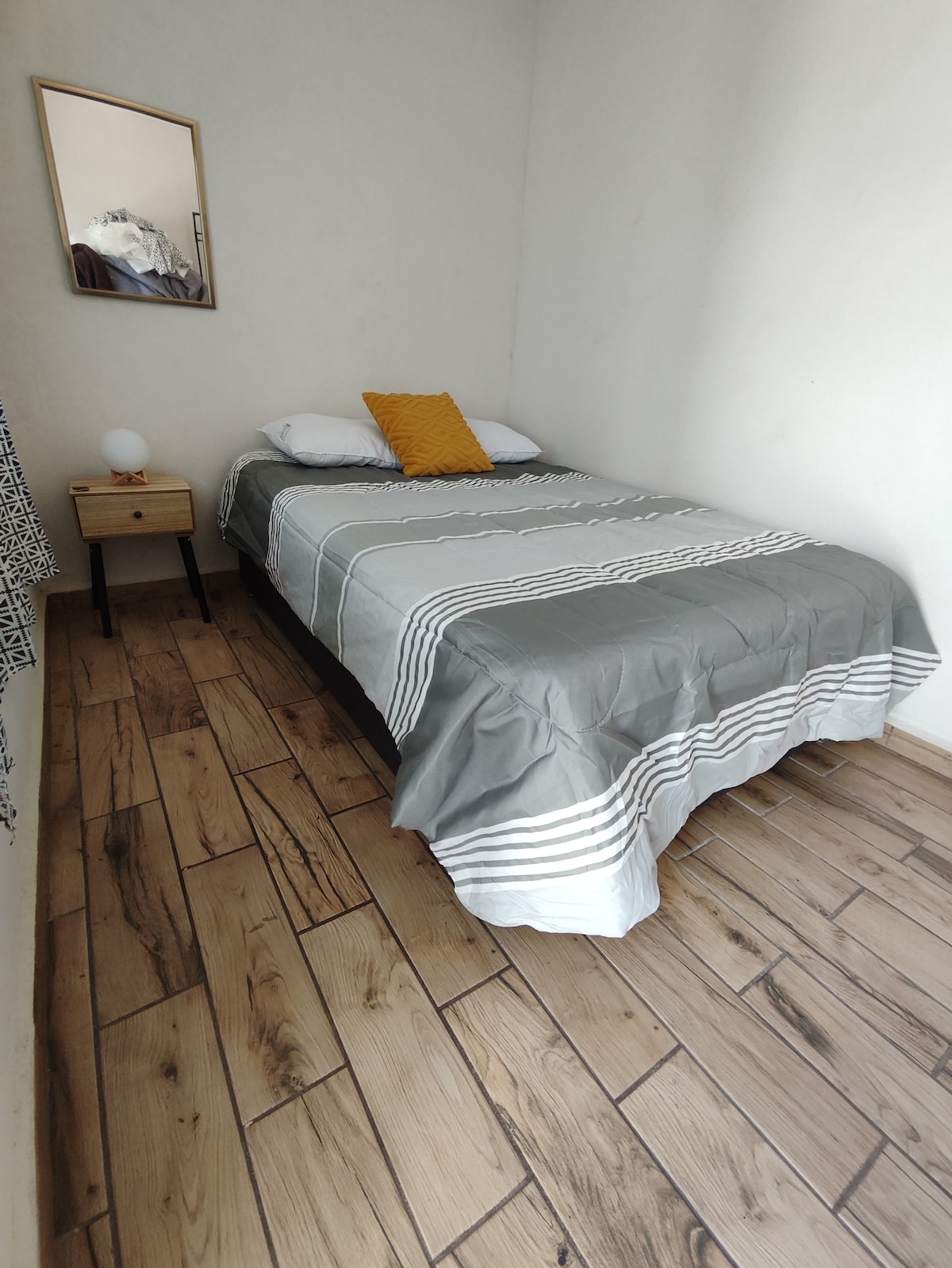 يوجد في غرفة النوم طاولة ليلية ومصباح لاسلكي ورف معطف وخطافات لتعليق الملابس ومناشف وبطانية إضافية ومكواة وحمار كي صغير.