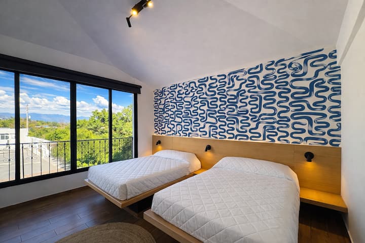 غرفة كبيرة بسريرين مزدوجين وحمام خاص وإطلالة مباشرة على حمام السباحة.