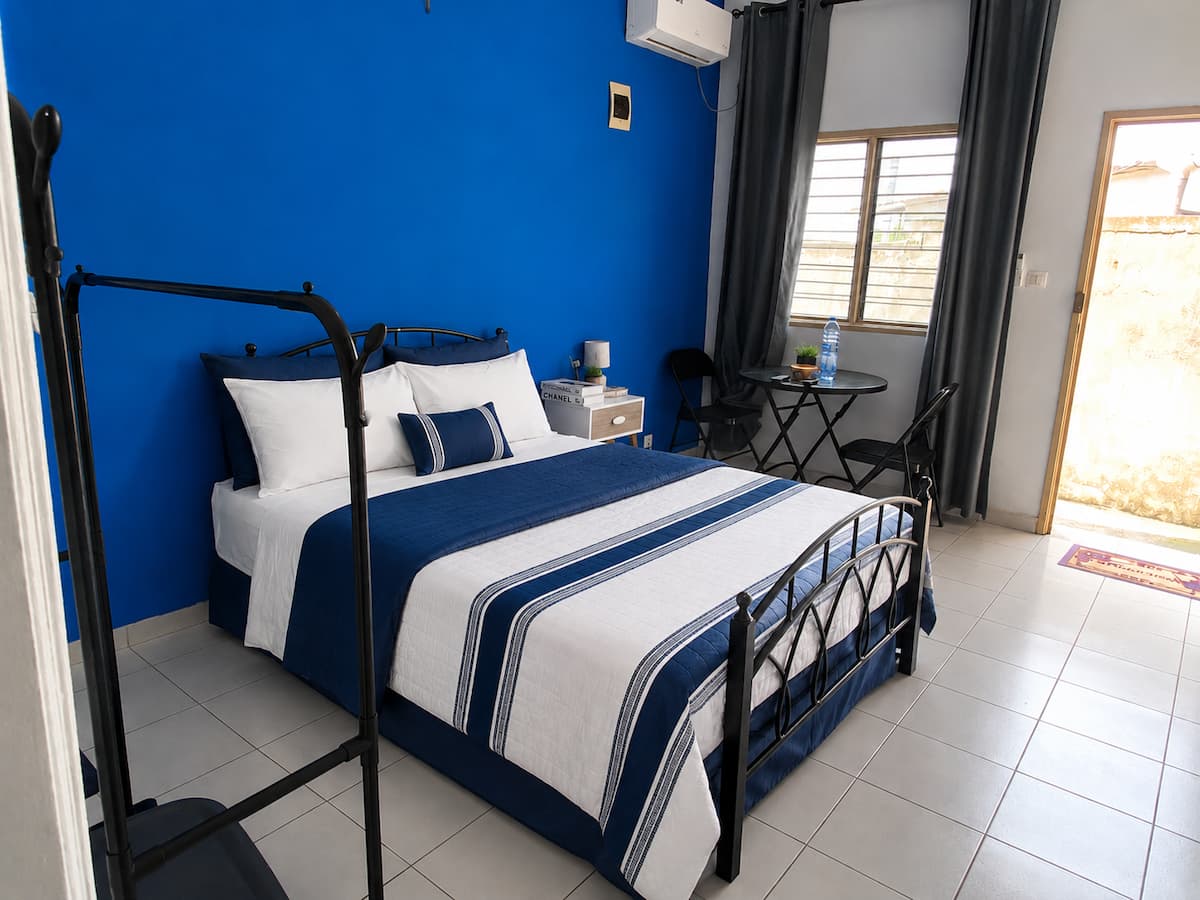 Studio C à Owendo : lit double et mur bleu