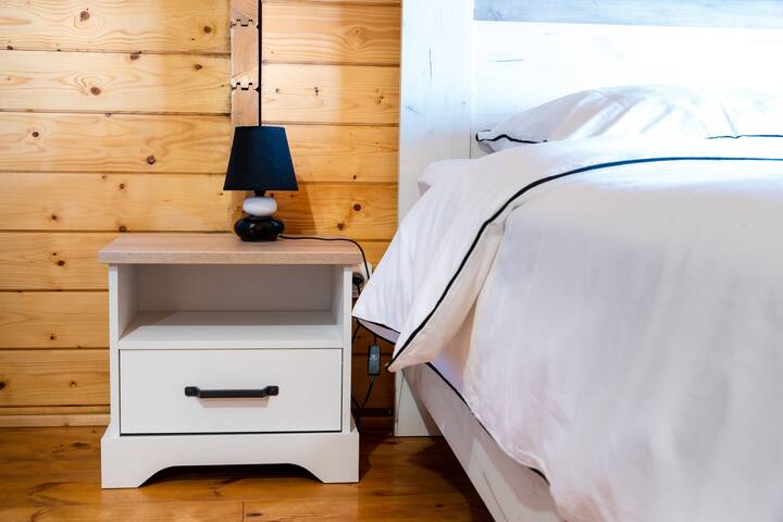 FR : Chambre bien dressée avec table de nuit et lampe, créant une ambiance chaleureuse et confortable.

ANG : Neatly arranged room with bedside table and lamp, creating a warm and cozy atmosphere.