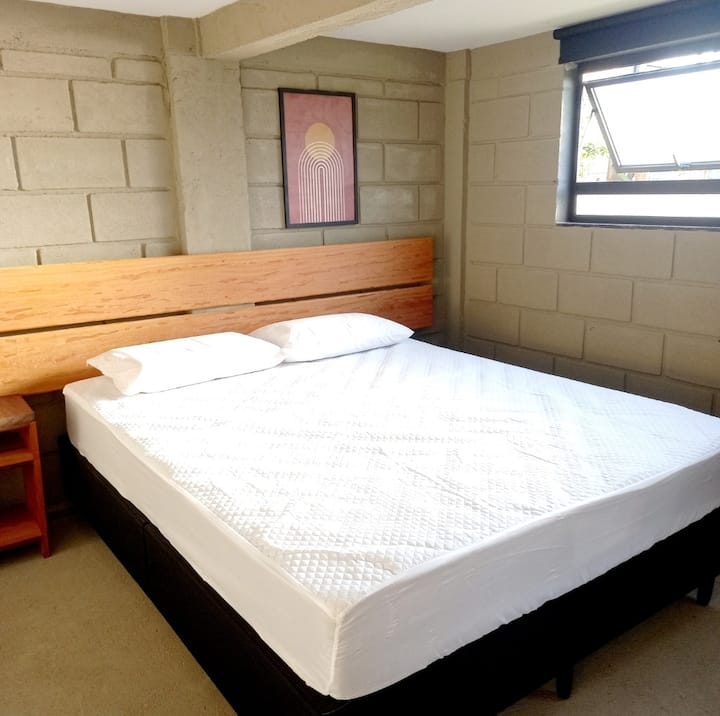 Quarto com acesso externo, banheiro e sofá cama
