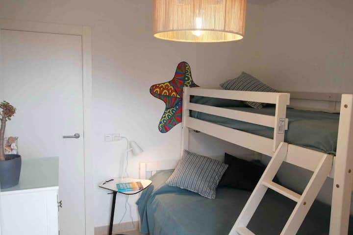 En køjeseng med en 135 cm bred seng nederst og en enkeltseng øverst, et stort skab, en kommode og en spektakulær havudsigt. Ideel til familier, der værdsætter komfort. Stående ventilatorer til de varmeste dage.