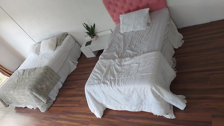 1 cama tamaño king y 1 cama hecha a medida que es más pequeña que una cama doble pero más grande que una cama individual. Tiene un armario con perchas. 