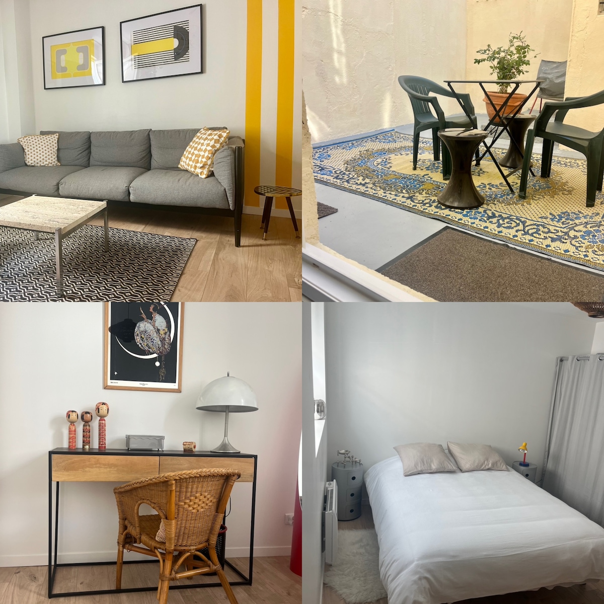 The living area includes a gray sofa, a patterned area rug, and abstract wall art. A small coffee table rests nearby. An outdoor terrace features a table and chairs, surrounded by a decorative rug. A work desk with a lamp is positioned beside a spacious queen bed in a well-lit bedroom.