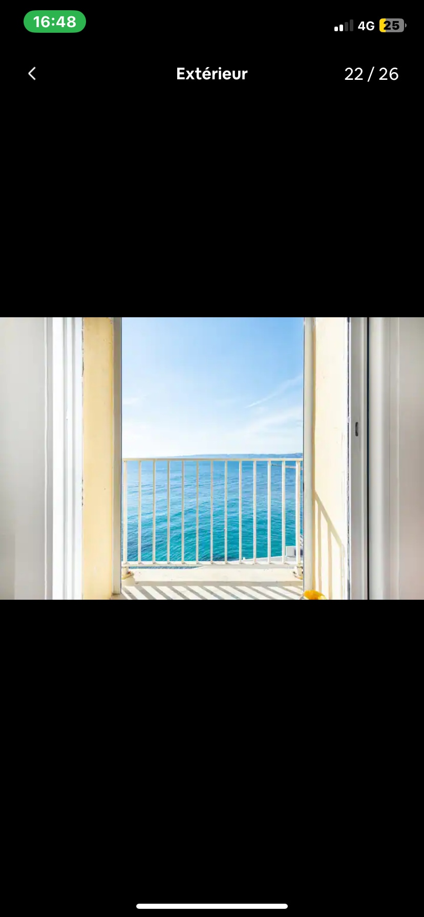 A clear view of the ocean is framed by an open door, showcasing a bright blue sky above calm waters. The white railing adds a touch of safety while allowing unobstructed sight lines to the serene seascape.