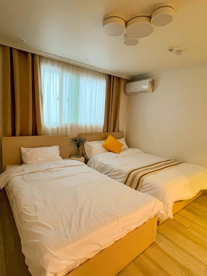 Ci sono 1 letto matrimoniale, 1 letto singolo, biancheria da letto dell'hotel, aria condizionata, toeletta e specchio.