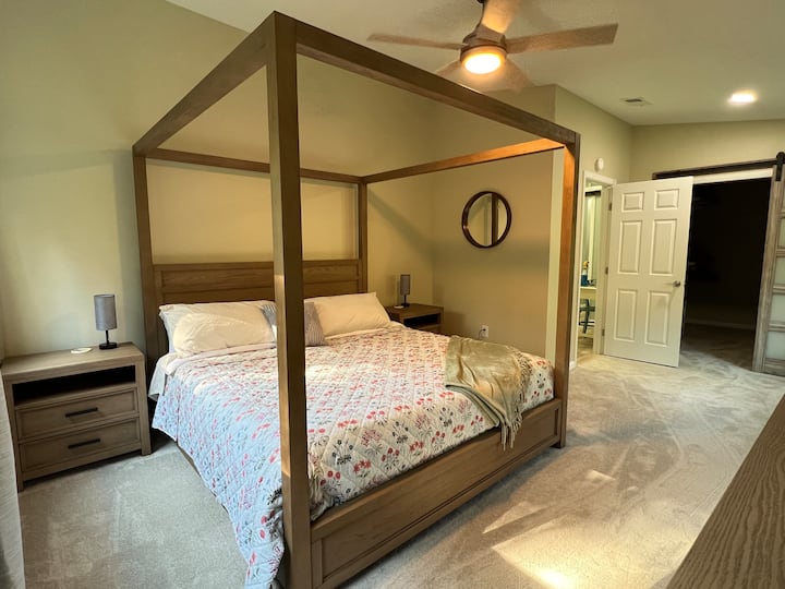 King size poster bed featuring the deluxe Purple 3 plush mattress - double nightstands, ceiling fan, 55" TV, wall mirror. 