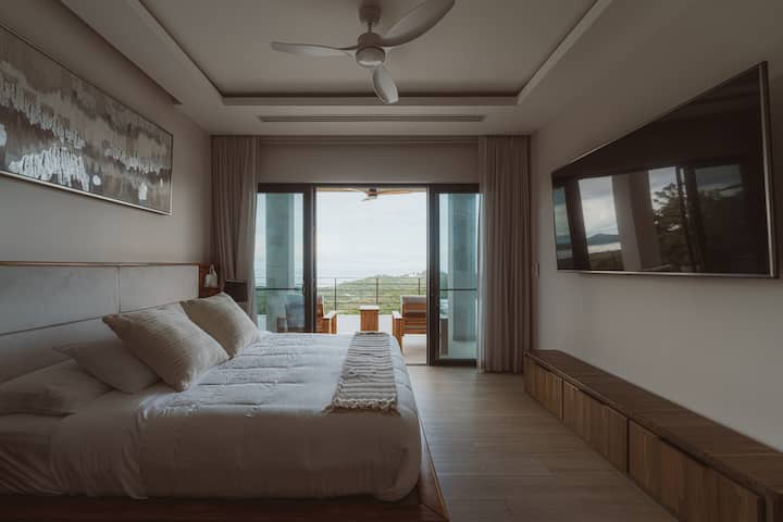 Štýlový apartmán na prízemí s manželskou posteľou veľkosti King, inteligentným televízorom a terasou len pár krokov od bazéna – ideálny na ranné kúpanie alebo večerný drink pri západe slnka. 