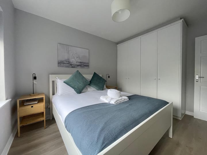 Cama tamaño king y armario doble completo con estanterías y espacio para colgar la ropa.