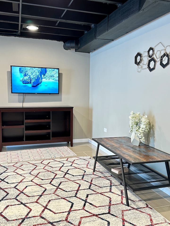 הסלון מציע תחושה מרווחת ומודרנית, עם ספה נוחה, טלוויזיה עם מסך שטוח והרבה אור טבעי. השטיח האופנתי מוסיף חמימות, מה שהופך אותו למקום נהדר להירגע ולהירגע אחרי יום עמוס של סיור.