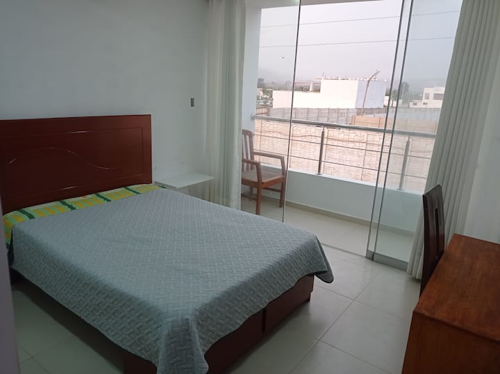 chambre avec un petit lit double, balcon et salle de bain privée