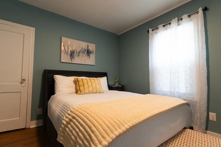 BD#1 A peaceful retreat with a cozy queen bed, gel cooling pillows, and soft bedding. The floating nightstand has LED lighting for ambiance and a charging station. The headboard has additional charging ports as well as under the bed storage drawers.