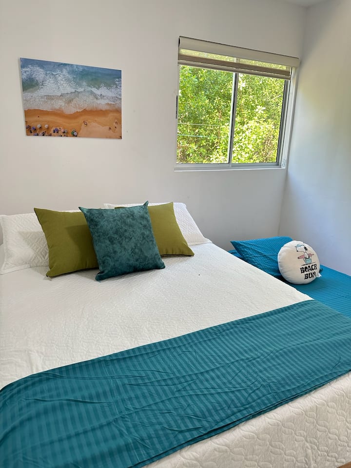 Cuenta con una cama doble y una individual, ambas con almohadas suaves para un buen descanso. Tiene aire acondicionado para mayor confort. La ventana grande aporta luz natural, y las persianas te permiten ajustar la claridad y privacidad.