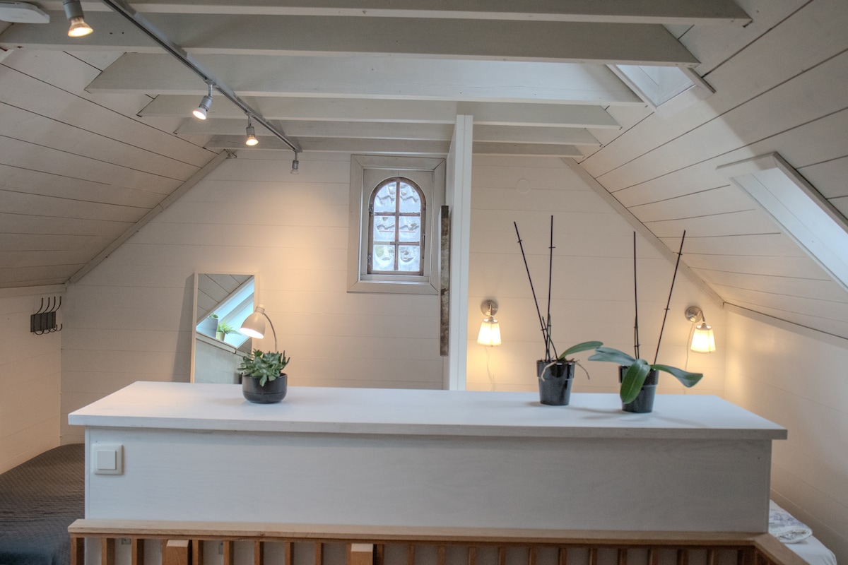 A la izquierda de la partición hay dos camas individuales. A la derecha de la partición hay una cama doble.