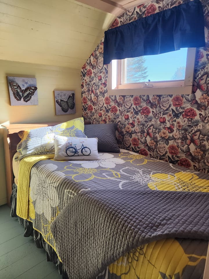 For extra sleeping space, a twin bed is tucked into the open area at the top of the stairs, outside the bedrooms
