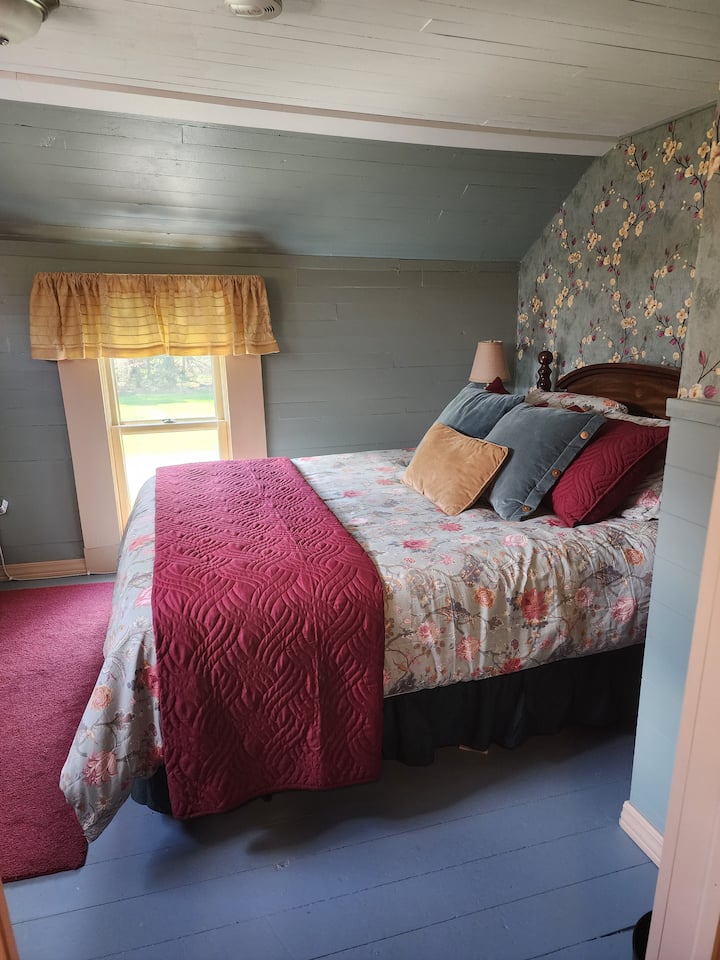 The green bedroom is upstairs and features a queen sized bed.