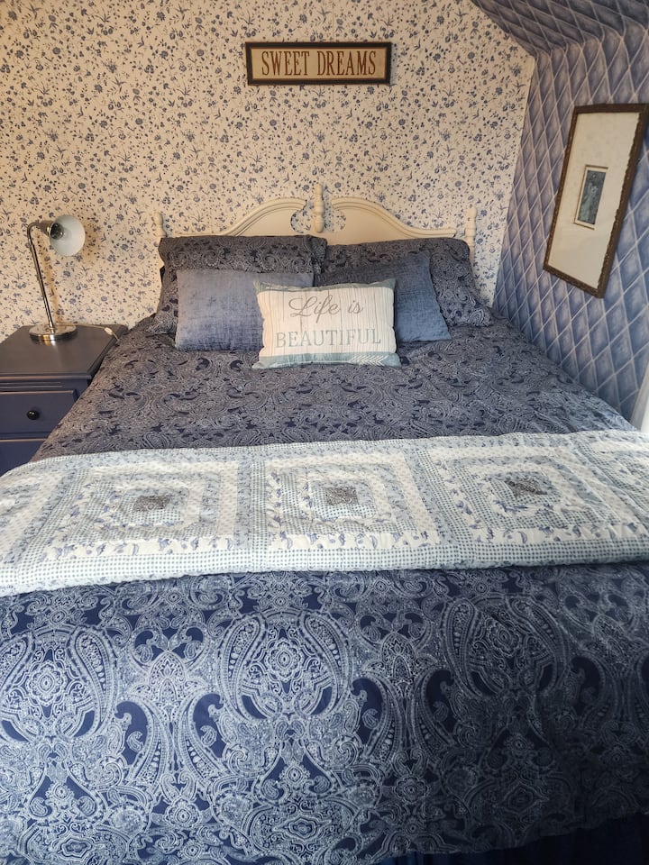 The blue bedroom is upstairs and features a queen sized bed. The half bath is inside the blue bedroom.